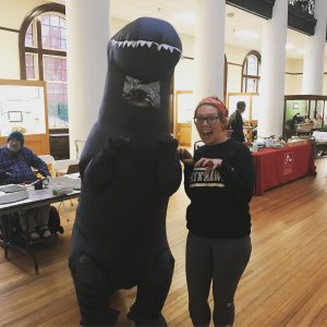 student standing with a person in a t-rex costume